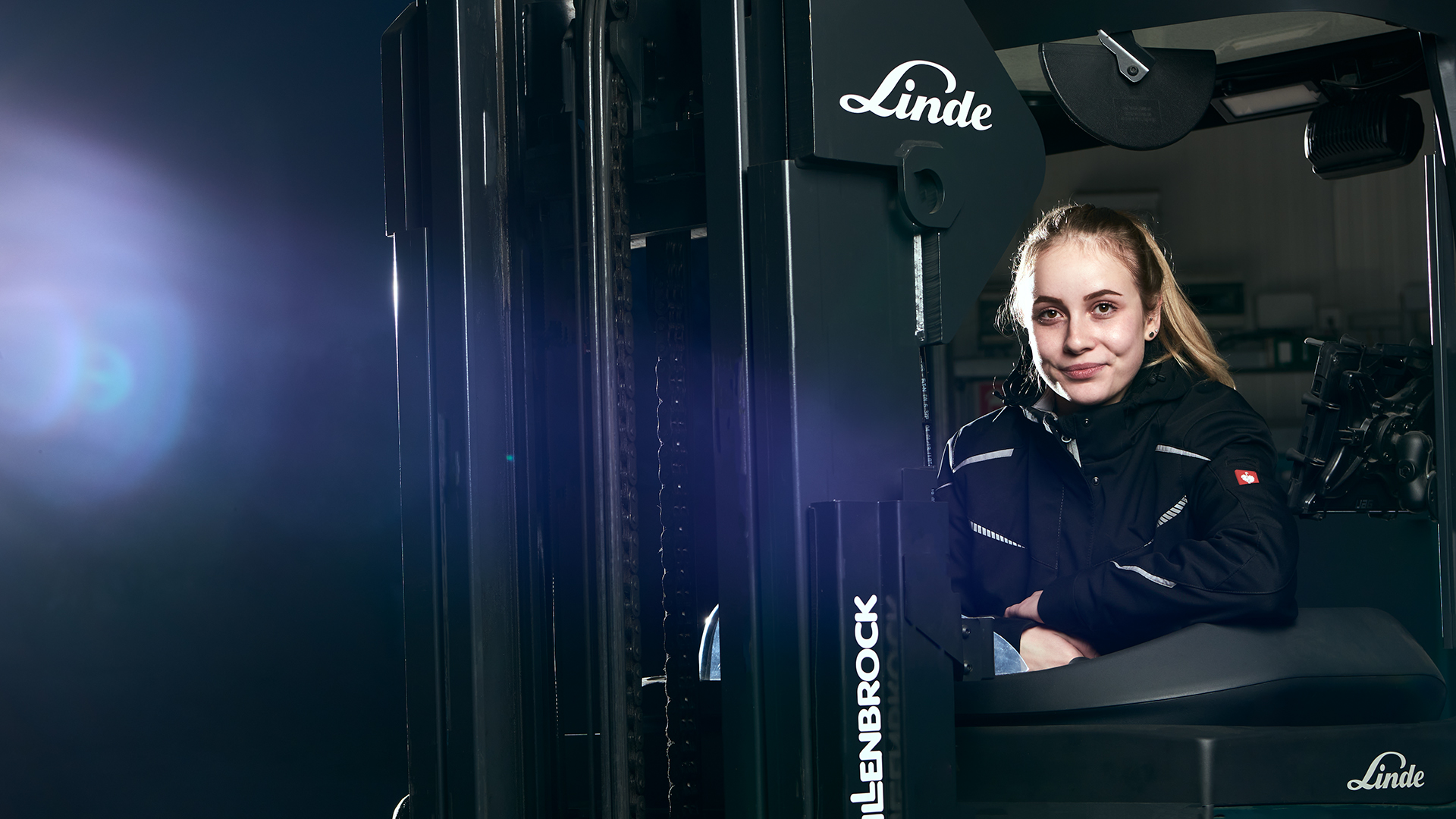 Junge Frau fährt Gabelstapler im Lager der hankensbütteler kunststoffverarbeitung – Quereinstieg in der Logistik.